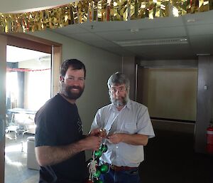 Two expeditioners putting up Christmas decorations