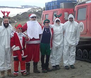 Expeditioners dressed as Santa, elves and reindeer pose for a photo