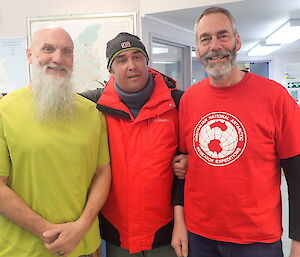 Three expedtioners pose for a photograph in the Operations building