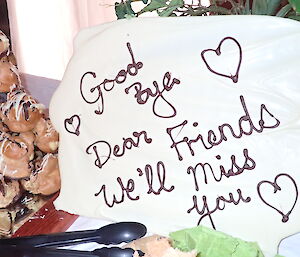 A chocolate sign with lettering that reads Goodbye Dear friends we'll miss you