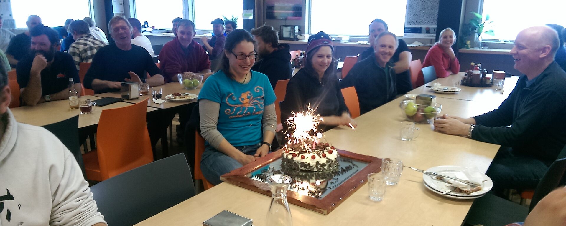 A picture of Nina Dehnard with her birthday cake complete with lit sparklers in the Davis LQ dining room