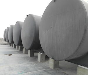 A row of round black fuel tanks at Davis Station