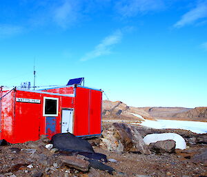 Watts hut against a vivid blue sky and rocky backdrop