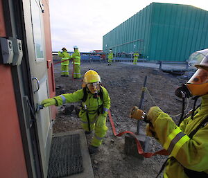 Two of the Davis Fire Team in protective clothing and wearing Breathing Apparatus enter the Emergency Power House while carrying out an exercise