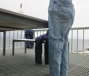 A pair of frozen jeans arranged as part of an art display on the decking in front of the Living Quarters at Davis station