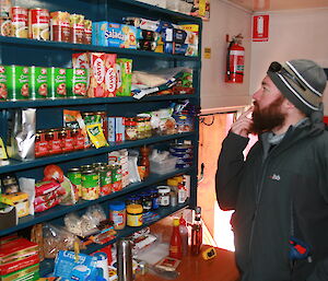 Karl Bettridge looks at the food supplies on the shelf at Brookes hut in the Vestfold Hills
