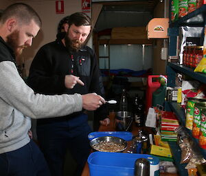 Scott McMillan and Cam Lea preparing a meal in Brookes hut in the Vestfold Hills