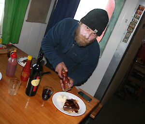 Dan Mizza with his steak and mashed ptoato meal at Brookes hut in the Vestfold Hills