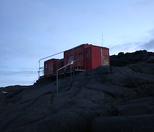 Evening falls over Brookes hut and the light of candles can be seen through the window — looking in from the outside