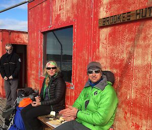 Three expeditioners outside Brookes hut in the Vestfold Hills eating lunch after a days hike