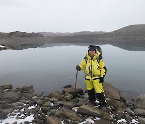 Aaron Stanley dressed in field survival gear, hiking along the side of Lake Stinear, a 3km long lake in the Vestfold Hills