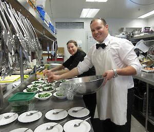 Lesley Eccles and Vas Georgiou plating up meals in the kitchen at Davis in preparation for a formal dinner