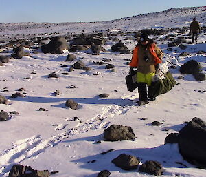 Aaron Stanley carrying gear to the AWS site in Heidemann Valley