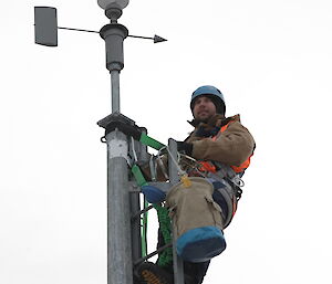 Aaron Stanley looking out at the view while 10 metres up the Davis anemometer doing the annual calibration