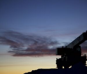 Sunrise and the silhouette of the grove RT540E crane parked up on heli pad at Davis for the winter