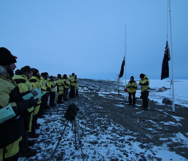 The members of the 69th ANARE beneath the flagpoles at the Davis Dawn Service on ANZAC Day