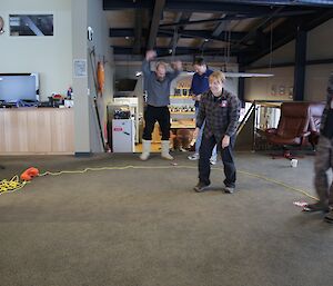 Within a two-up ring defined by throwbag rope Ali Dean spins the coins and throws Heads while Craig Butsch the Ring Master looks on and Darren White jumps for joy at winning