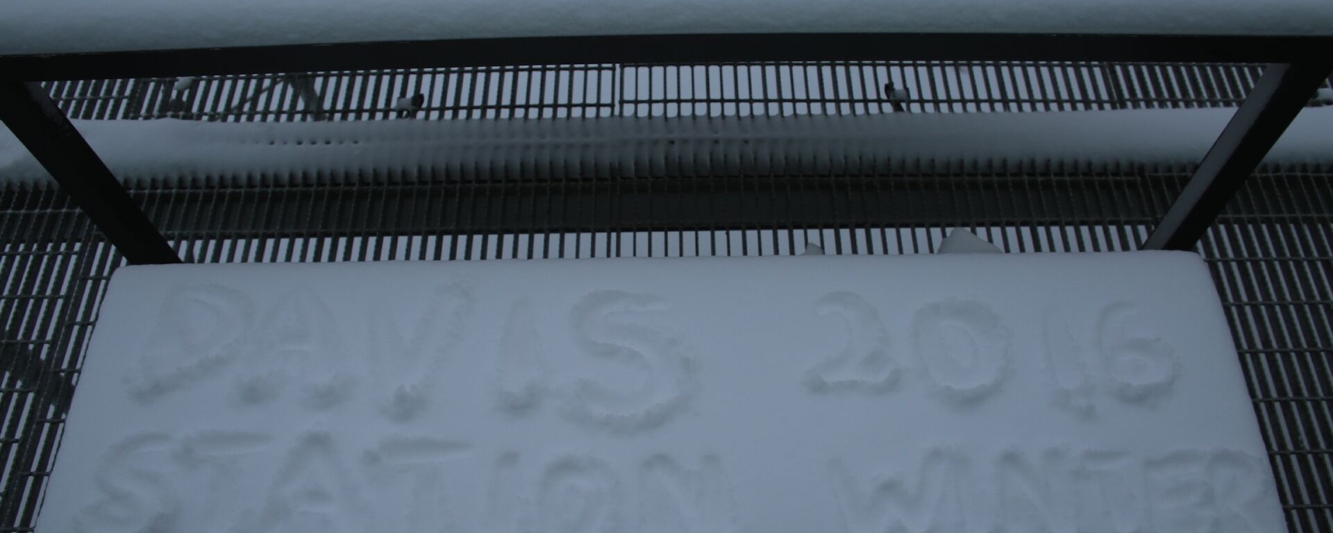 Seat on the balcony at Davis topped with fresh snow that then has ‘Davis Station 2016 Winter’ written on it