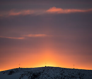 Sun’s rays illuminate the three crosses on top of Anchorage Island