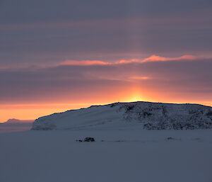 Sun’s rays illuminate the three crosses on top of Anchorage Island and form a light pillar shines up to the skies above