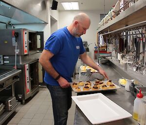 Michael Goldstein taking a tray of freshly baked chocolate scrolls out of the oven