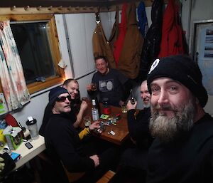 Five expeditioners in Bandits hut for the evening about to play cards