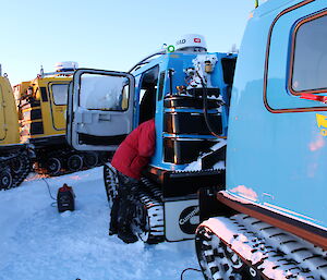 Paul Bright readies the blue Hagglund engine to start at around −30 degrees C on the ice plateau at Woop Woop