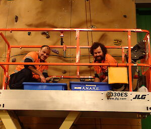 Vas Georgiou and Chris Burns cleaning the rock climbing wall in the Green store at Davis