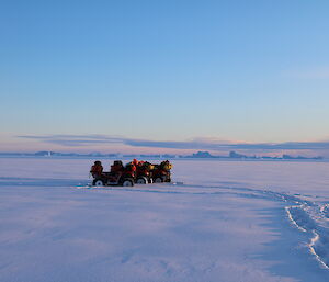 Quad bikes out on the sea ice in front of Davis Station on a clear cold winters day