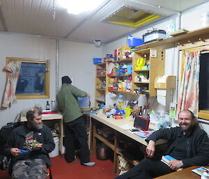A view inside Bandits hut with the occupants huddled around the gas heater, one is preparing the evening meal at the stove top