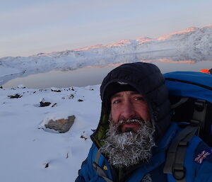 Darren White with frosty beard in front of Deep Lake