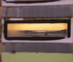 The golden glow in the sky, reflections in the window of the old living quarters