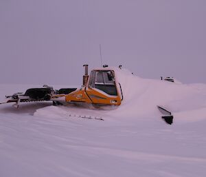 A groomer up at Woop Woop buried in snow prior to being dug out