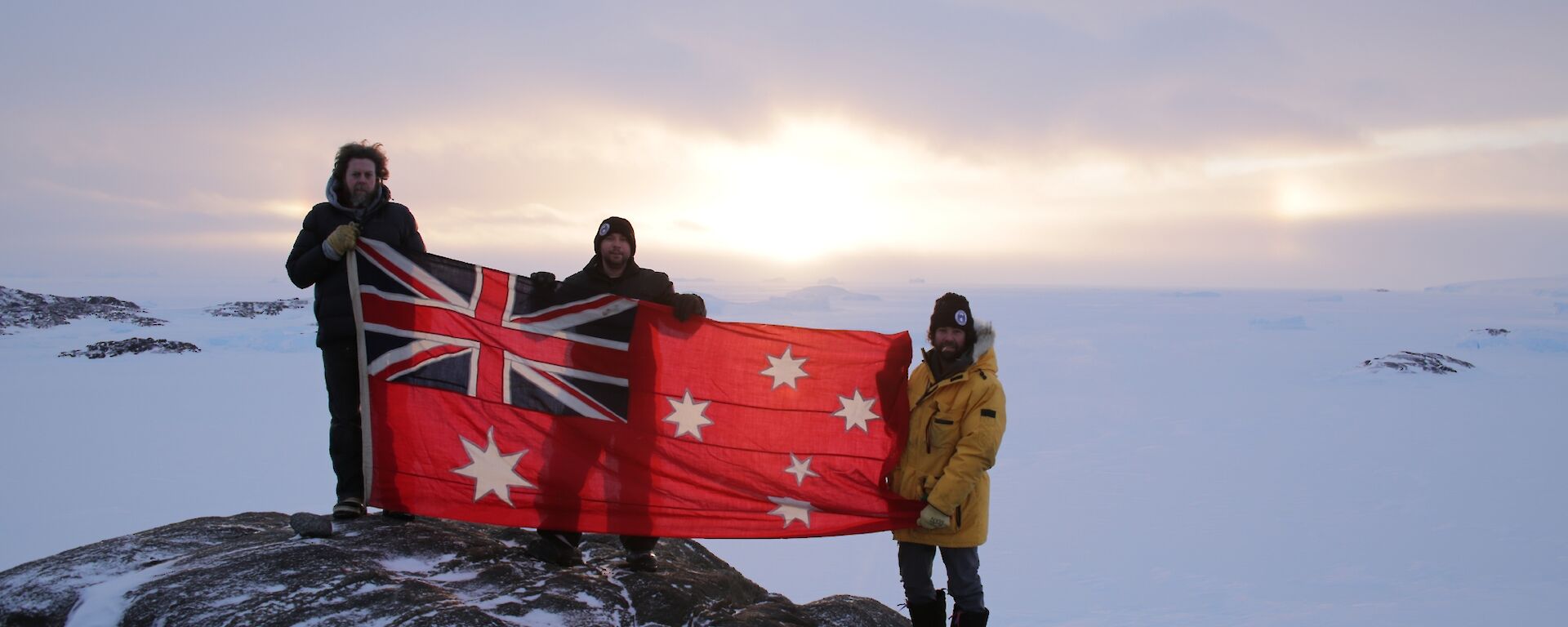 Scott, Aaron and Chris with Sir Hubert Wilkins flag at Walkabout Rocks in the Vestfold Hills