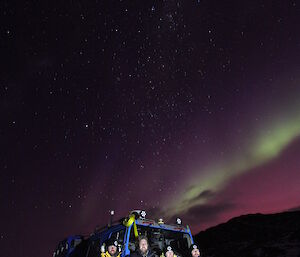 A team of four outside Watts hut watching the aurora in August