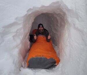 Darren White gives the thumbs up to indicate a good nights sleep in his snow cave and bivy