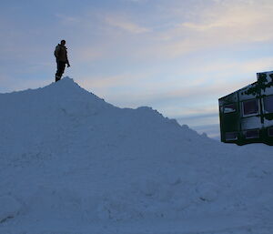 Paul Bright on top of a mountain of snow outside the Operations building at Davis