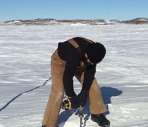 Dr John Parker drills down into thick sea ice over one and a half metres thick in front of Davis station