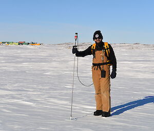 Dr John Parker holding the snow thickness measuring equipment on the sea ice in front of Davis