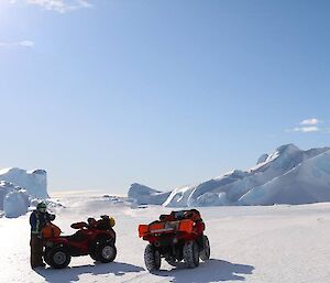 An expeditioner with two quad bikes on the sea ice