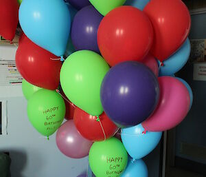 A bunch of helium filled balloons tied to the station leaders office door