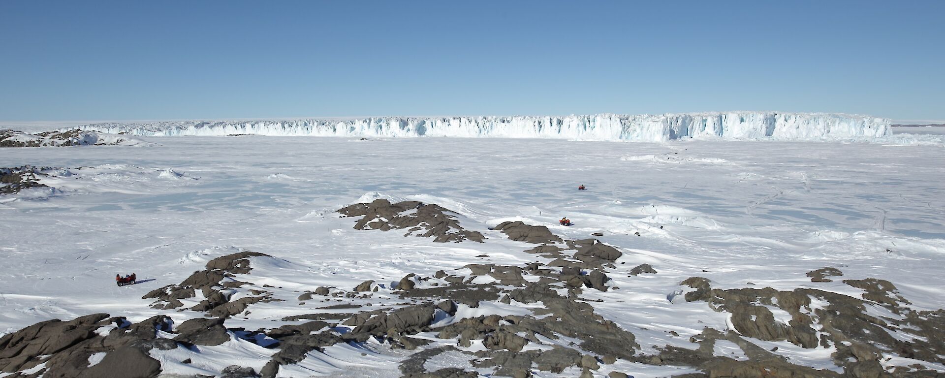 A picture of a very big glacier called Sørsdal Glacier with quad bikes in the foreground