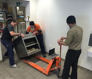 Dave Davies, Paul Deverall, and Brett Sambrooks remove kitchenware at Davis