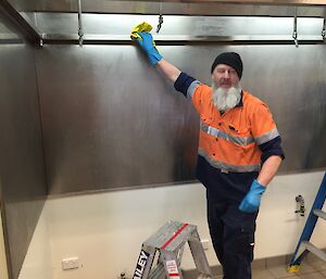 Paul Deverall cleaning the stainless steel lining of the rangehood