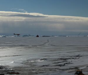 A plane landing on the Davis skiway with the ship in the background