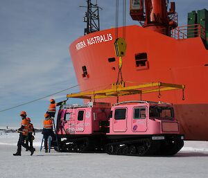 Opal, our new pink Hagglund, is lifted out of the ship’s hold using a crane, and is being gently lowered onto the fast-ice where the crew unpack her, and get her ready to drive into station.