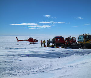 Helicopter landed next to vehicles.