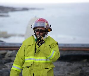 Paul, also known as “Sharky”, is in full fire fighting gear, walking around down near the Emergency Power House where the faux fire has been detected during a fire drill exercise. He is calling on his hand held VHF radio for the fire truck Hagglund to join him.