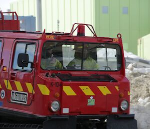 Richard (Station Mechanical Supervisor), Darren (electrician) and Lotter (Electronics Engineer), are inside the red fire truck Hagglund, driving through station, with snow, ice and station buildings behind them, heading towards the building involved in the fire drill exercise.