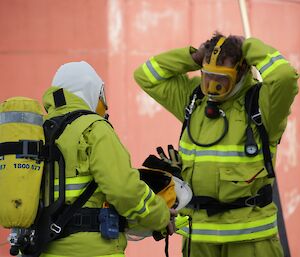 Kerryn and Jock are now putting on their masks for the breathing apparatus gear. They are now breathing air from tanks. Helping each other to gear up as a safety measure, as part of a buddy system.